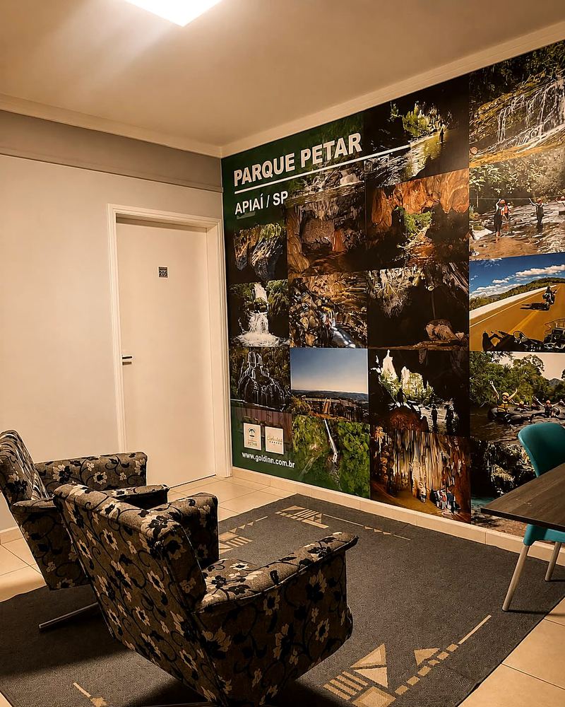 Área de estar do Gold Inn Hotel com painel do PETAR