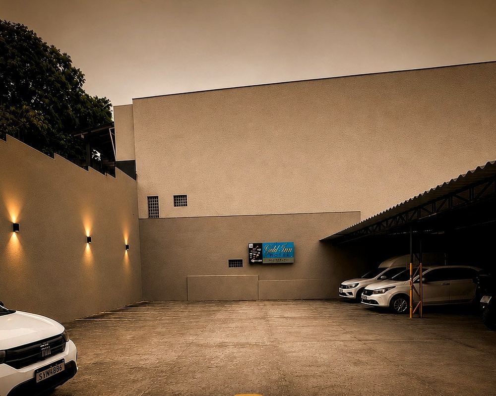 Pátio coberto do estacionamento do Gold Inn Hotel, com vagas para hóspedes